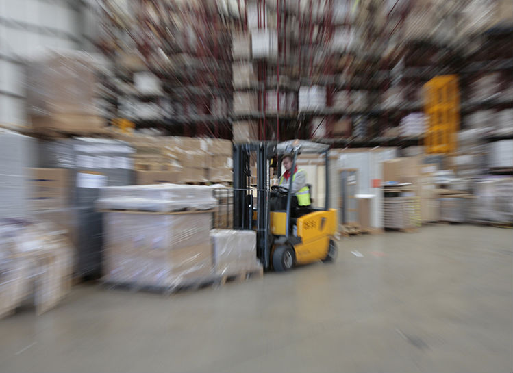 moving fork lift in warehouse